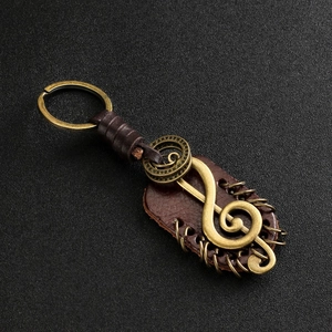 Vintage bronze treble clef leather keychain with rustic braided strap and metal details