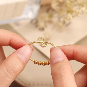 Stress relief gold spinning ring with movable beads and twisted knot design for women