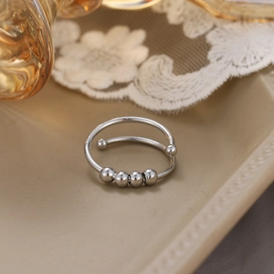 Silver stainless steel fidget ring with four moving beads for stress and anxiety relief