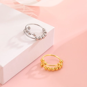 Detail view of gold and silver spinning fidget rings for anxiety relief on display stands