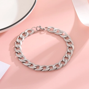 Detail view of silver stainless steel Cuban link bracelet with embossed grid texture