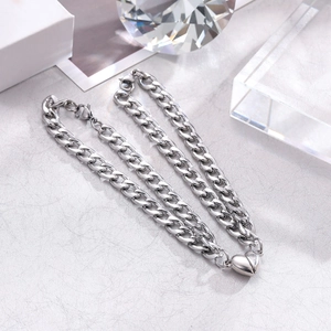 Macro detail of silver stainless steel Cuban link bracelet with magnetic heart clasp