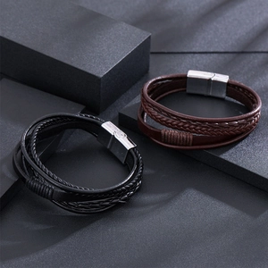 Gros plan de bracelets en cuir tressé noir et marron avec fermoirs magnétiques argentés