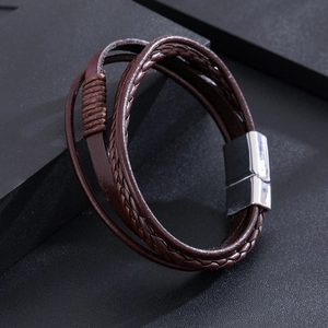 Détail d'un bracelet en cuir tressé marron avec un fermoir magnétique en métal argenté