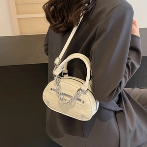 Sac bandoulière ovale blanc minimaliste avec chaîne argentée et rivets sur mannequin