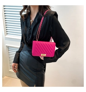 Pink quilted shoulder bag with V-shaped stitching and gold chain strap on model