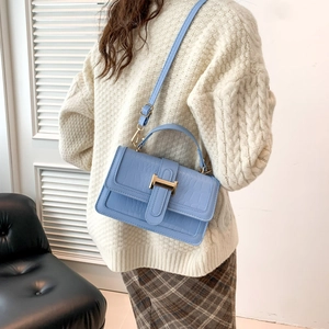 Light blue faux crocodile leather crossbody bag with gold H clasp worn by model