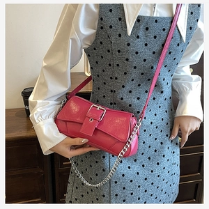 Detail of fuchsia vintage leather shoulder bag with silver chain and buckle accent
