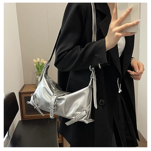 Detail of silver metallic shoulder bag with belt buckles in Y2K industrial style