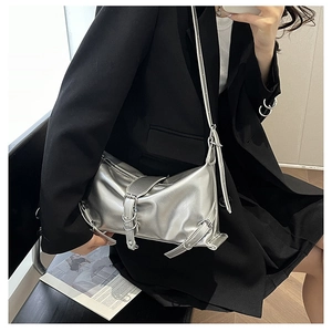 Detail of silver metallic shoulder bag with decorative metal buckles and pleated texture