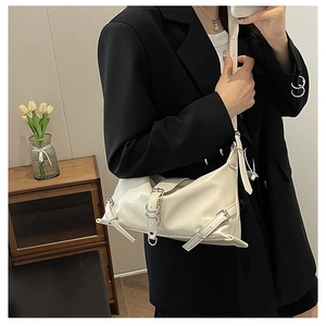 Detail of cream leather shoulder bag with adjustable buckles and pleated texture