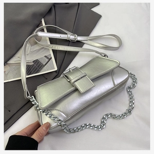 Detail of silver metallic crossbody bag featuring textured faux leather and chunky chain
