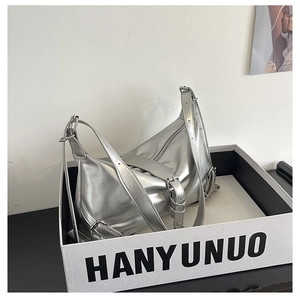 Silver metallic shoulder bag with pleated texture and adjustable buckles in a display box