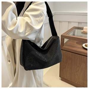 Gros plan des strass noirs scintillants et du velours doux sur ce sac porté épaule chic