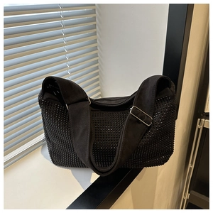 Detail einer schicken schwarzen Strass-Schultertasche mit breitem Gurt am Fenster