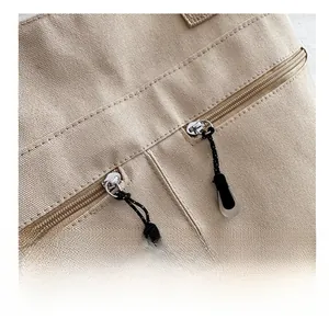 Détail des doubles fermetures éclair et de la texture en toile du sac fourre-tout