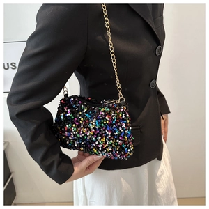 Detail of colorful sequined crossbody bag with a gold chain strap worn by a model