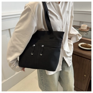 Détail du sac cabas en toile noire avec doubles poches zippées et grande contenance