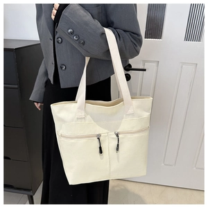 Détail du sac cabas en toile crème avec deux fermetures éclair et texture résistante