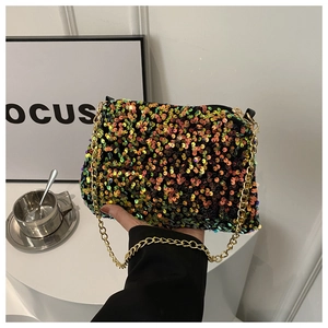 Close-up of sparkling iridescent sequins and gold chain strap on small shoulder bag