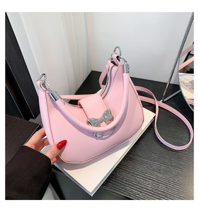 Détail du sac croissant rose avec boucle noeud argentée et bandoulière assortie