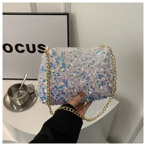 Close-up of white sequin chain bag with iridescent finish and gold hardware strap