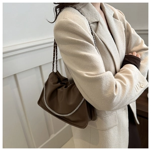 Detail view of dark brown pleated leather shoulder bag with silver chain and strap