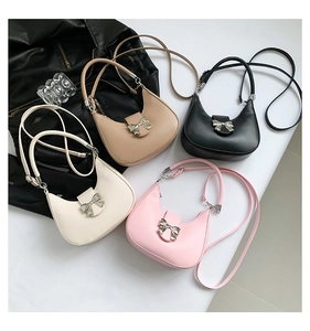 Détail de quatre sacs hobo avec boucles nœud argenté en cuir noir, crème, blanc et rose