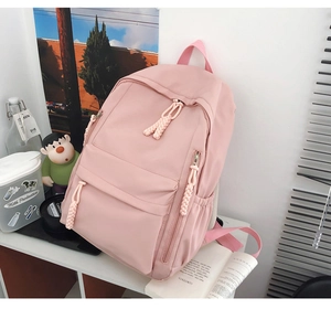 Detail of pink minimalist backpack with waterproof fabric and woven rope zipper pulls