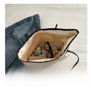 Top-down view of a large white nylon tote bag showing spacious interior with zipper closure