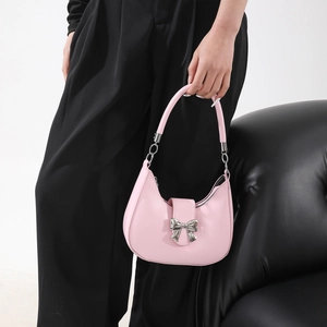 Sac à main demi-lune rose avec détail nœud argenté et poignée courbée élégante