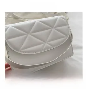 Detail shot of white quilted shoulder bag with geometric stitching and soft leather texture