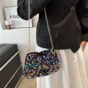 Sac à bandoulière en paillettes multicolores avec chaîne dorée porté par un mannequin