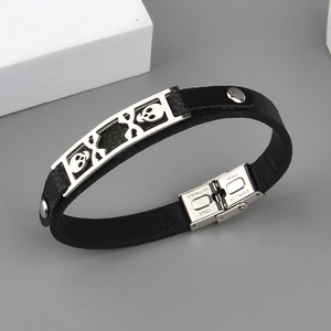 Detail of stainless steel clasp and skull ornament on a black leather punk bracelet
