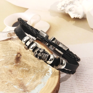 Dettaglio del bracciale multistrato in pelle con teschio d'argento e perline in metallo