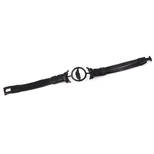 Macro detail of retro black leather bracelet with matte feather charm and buckle clasp