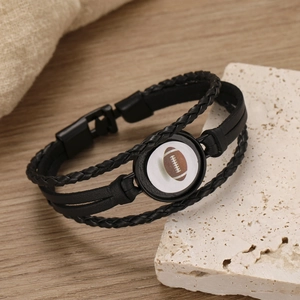 Handmade black braided leather mens bracelet featuring a soccer ball charm and metal clasp