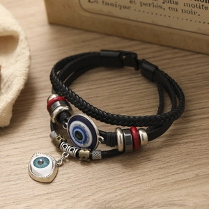 Detailed close-up of a multi-layer leather Evil Eye bracelet with ethnic beads and charms