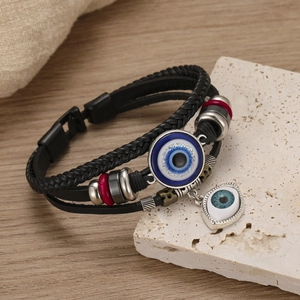 Detailed view of multilayer leather evil eye bracelet on rustic stone and wood background