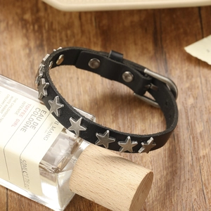 Gros plan d'un bracelet punk gothique en cuir noir avec rivets étoiles et boucle argent