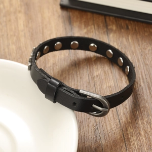 Détail du bracelet punk en cuir noir avec rivets métalliques et fermeture à boucle