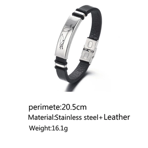 Detail of black leather bracelet featuring a polished steel plate with bird engraving