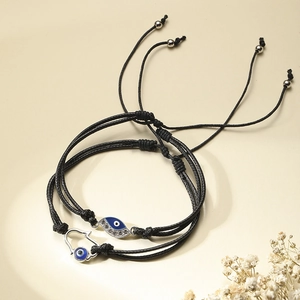 Bracelets réglables œil protecteur et main de fatma en cordon noir sur fond beige