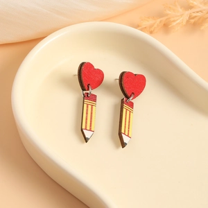 Charming wooden pencil heart earrings for teachers on a minimalist ceramic tray