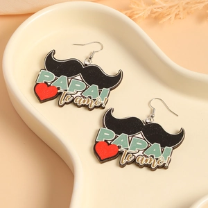 Detail view of wood Papa Te Amo earrings with mustache and heart design on tray