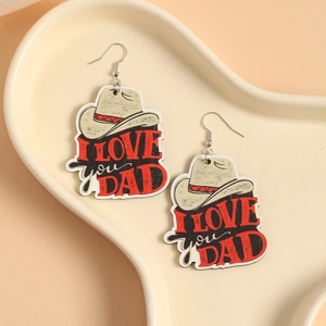 Detail of wooden cowboy hat earrings with I LOVE DAD text on a decorative tray
