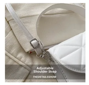 Close-up of adjustable white PU leather shoulder strap with silver metal buckle on quilted bag