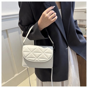 Chic white quilted crossbody bag with flap cover shown on model in a stylish outfit
