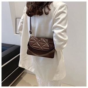 Deep brown quilted crossbody bag with triangular stitching shown on a person