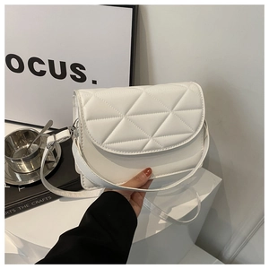 Detailed view of white quilted crossbody bag with geometric triangle stitching and thin strap